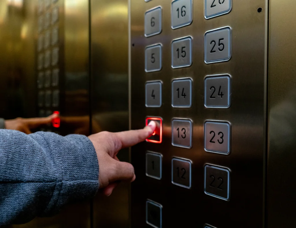 Person pressing elevator button to the lobby