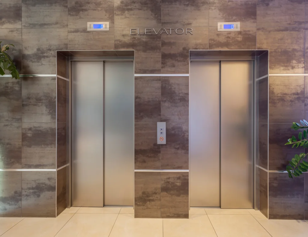 Two elevators surrounded by marble